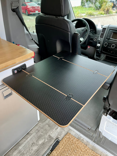 Folding Black Hex Lagun Table, 1/2" thick for camper vans and RVs, priced at $279.00. Measures 21 1/2"x14" folded and 21 1/2"x28" extended. Made of 1/2" Black Hex laminated Baltic Birch with beveled edges and rounded corners. Includes four mortised flush mount hinges. No mount included.