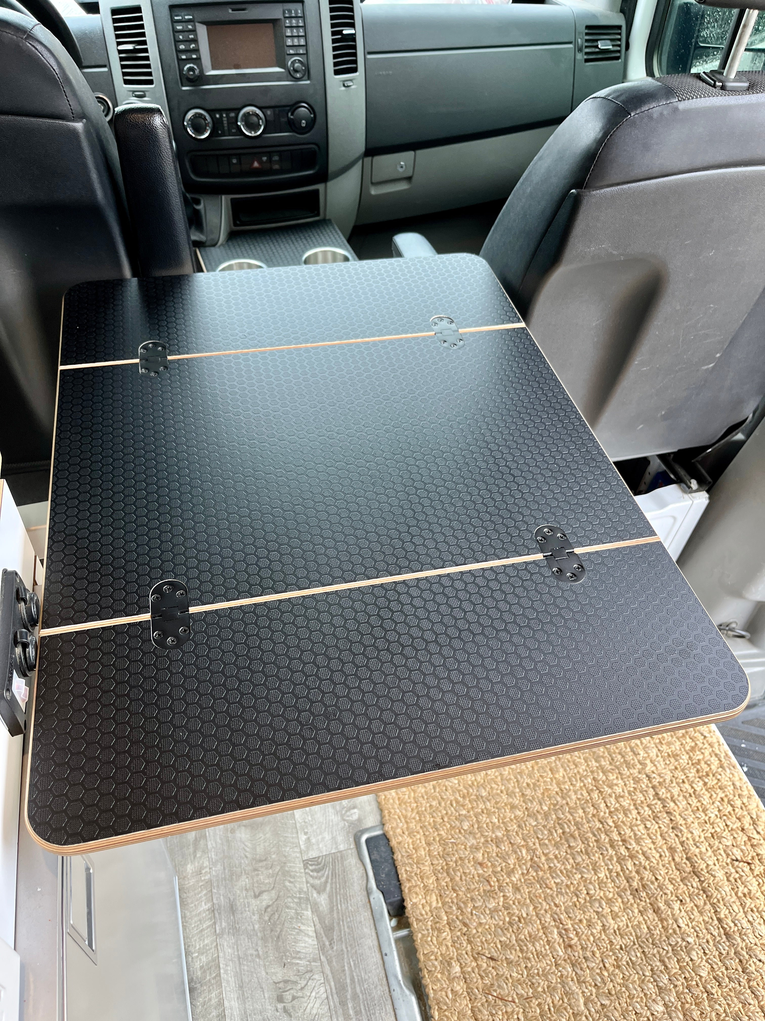 1/2" thick Folding Black Hex Laminated Baltic Birch Table for camper vans and RVs. Dimensions: 21 1/2"x14" folded, 21 1/2"x28" extended. Features Rubio Monocoat Natural Oil Finish, beveled edges, and four mortised flush mount hinges. Weighs 7lb 14oz. Free shipping in the lower 48 USA.