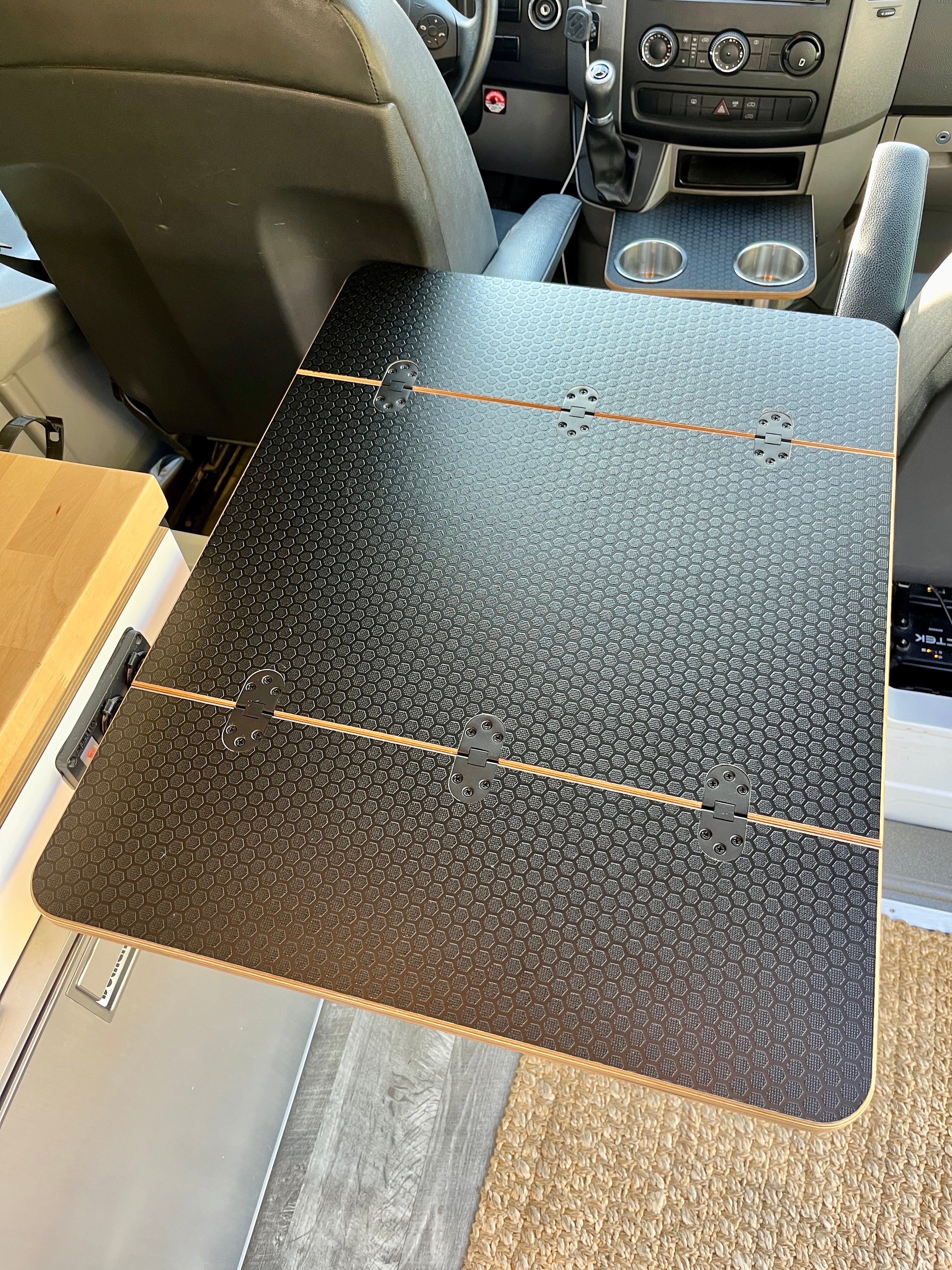 3/4" thick Folding Black Hex Laminated Baltic Birch Table for camper vans and RVs. Dimensions: 21 1/2"x14" folded, 21 1/2"x28" extended. Features Rubio Monocoat Natural Oil Finish, beveled edges, and six mortised flush mount hinges. Weighs 11lb 12oz. Free shipping in the lower 48 USA.