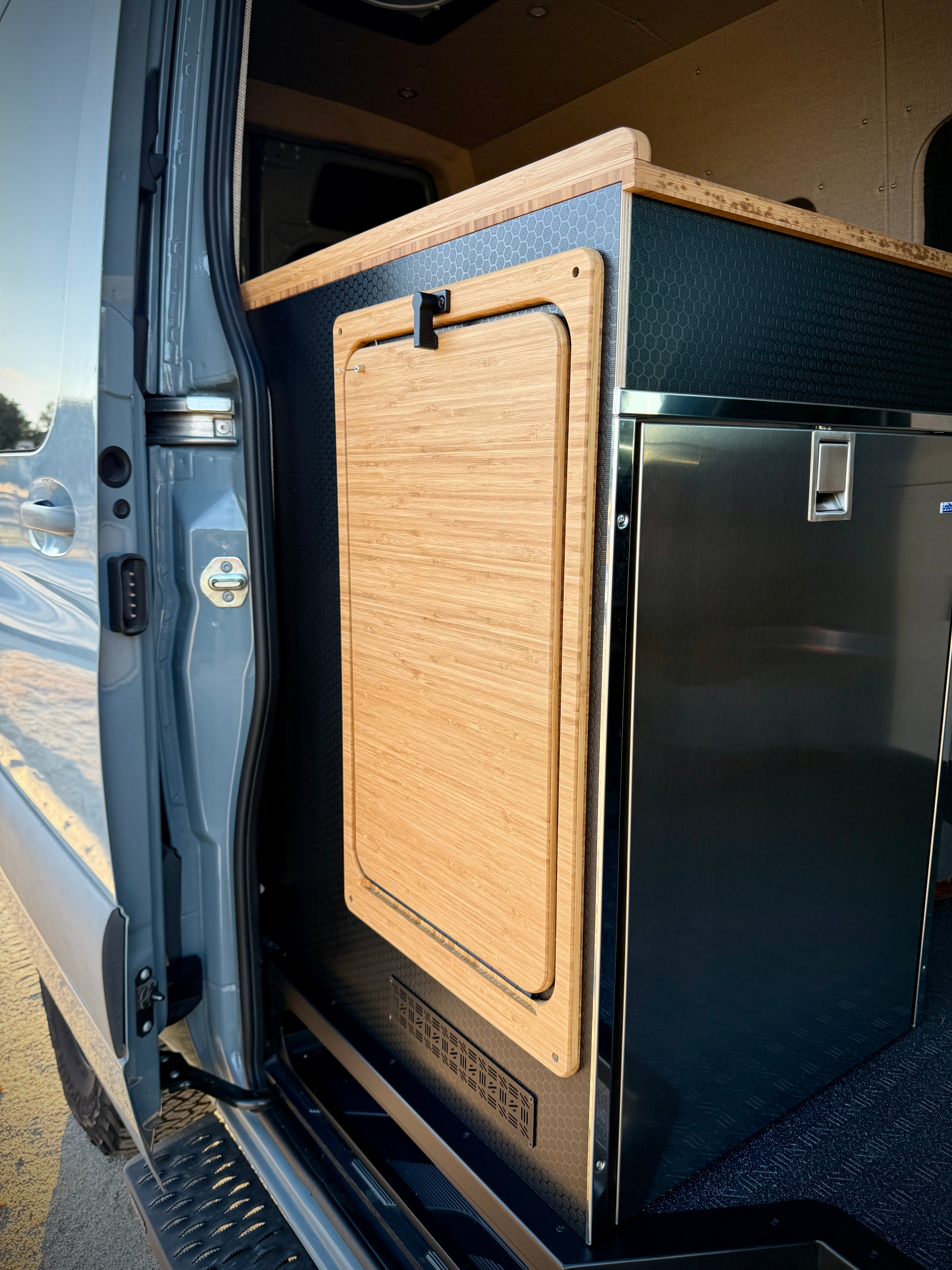 Bamboo folding table attached to a camper van kitchen