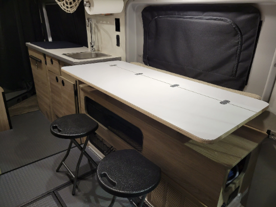 A versatile lift-up table designed for 2020-2022 Winnebago SOLIS Class B RVs, featuring a 3/4" bamboo surface. It can be easily raised and lowered, providing a 48" x 22.5" workspace when the murphy bed is in the raised position. 